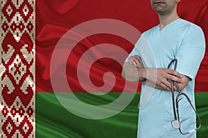 Partial photograph of a doctor with a stethoscope in a professional medical uniform against the background of the national flag of
