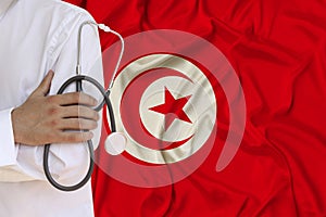 Partial photograph of the doctor in uniform against the background of the national flag of Tunisia on delicate shiny silk, the