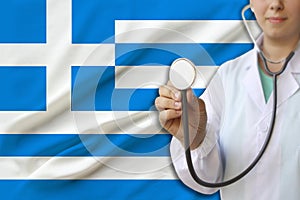 Partial photograph of a doctorâ€™s girl, a nurse with a stethoscope in uniform against the background of the colored national flag