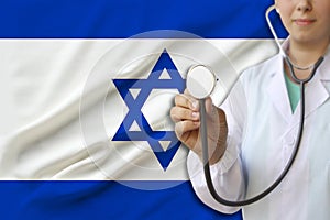 Partial photograph of a doctorâ€™s girl, a nurse with a stethoscope in uniform against the background of the colored national flag