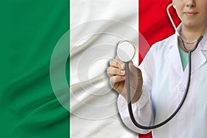 Partial photograph of a doctorâ€™s girl, a nurse with a stethoscope in uniform against the background of the colored national flag