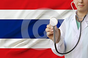 Partial photograph of a doctorâ€™s girl, a nurse with a stethoscope in uniform against the background of the colored national flag