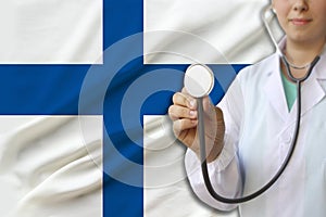 Partial photograph of a doctorâ€™s girl, a nurse with a stethoscope in uniform against the background of the colored national flag