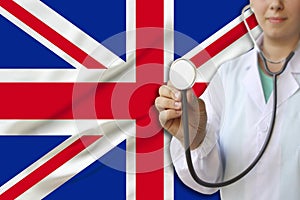 Partial photograph of a doctorâ€™s girl, a nurse with a stethoscope in uniform against the background of the national flag of the