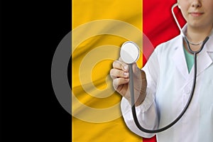 Partial photograph of a girl doctor, nurse with a stethoscope in uniform against the background of the national flag of the state