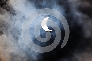 Partial solar eclipse through clouds