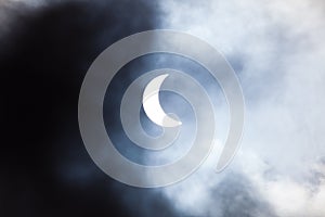 Partial solar eclipse through clouds