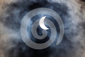 Partial solar eclipse through clouds