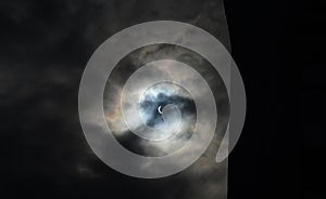 Partial solar eclipse viewed under cloudy skies