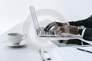 partial view of african american businessman typing on laptop at workplace