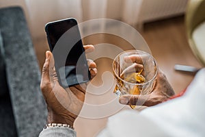 Partial view of african american man with glass of whiskey