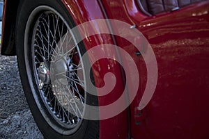 Partial view of back of vintage car with spoke wheel