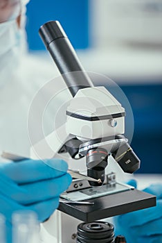 View of biochemist looking through microscope at small stone