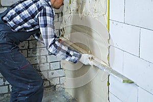 Partial view of builder plastering on block wall