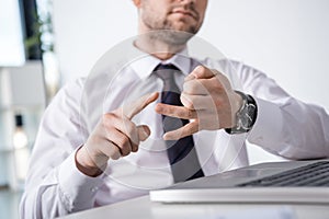 Partial view of businessman counting on fingers at workplace