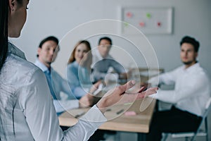 partial view of businesswoman and colleagues behind at workplace