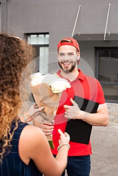 partial view of client and smiling delivery man
