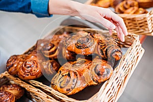 partial view of female hand and pastry in basket