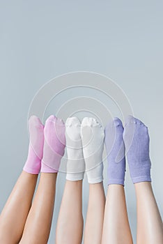 partial view of female legs in different colorful socks