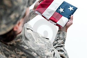 partial view of male soldier in military uniform with american flag