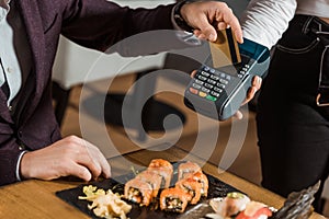 Partial view of man paying by credit card for dinner