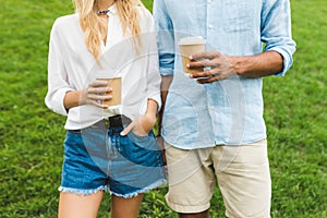 partial view of man and woman holding coffee to go