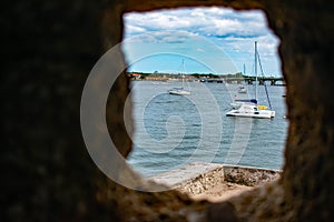 Partial view of Matanzas river and sailboats from Stone Turret window in Castillo de San Marcos Fort at  Florida`s Historic Coast.