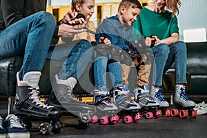 partial view of parents helping kids to wear protection before skating