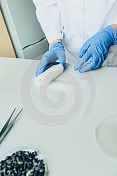 partial view of scientist in latex gloves working at table in modern