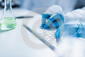 partial view of scientist typing on