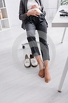 partial view of shoeless pregnant woman