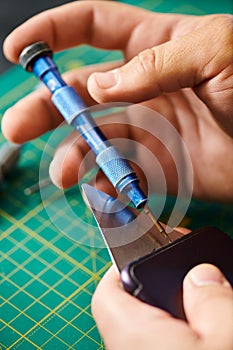 partial view of technician opening smartphone