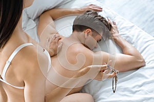 partial view of woman with cuffs and shirtless caucasian boyfriend