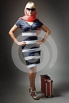 partial view of woman holding retro suitcase isolated on grey