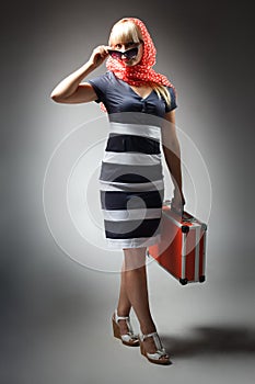 partial view of woman holding retro suitcase isolated on grey