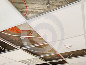 Partially open suspended ceiling with fixtures and appliances visible