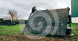 Participant in obstacle course climbing pyramid obstacle