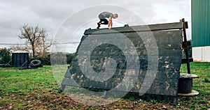 Participant in obstacle course climbing pyramid obstacle