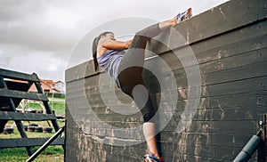 Participant in obstacle course climbing wall