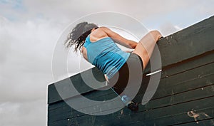 Participant in obstacle course climbing wall