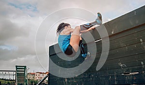 Participant in obstacle course climbing wall
