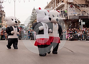 Participants dressed in large inflatable suits are walking along