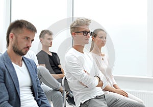 Participants in the group meeting applaud, sitting in one row
