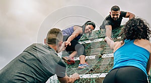 Participants in obstacle course climbing net