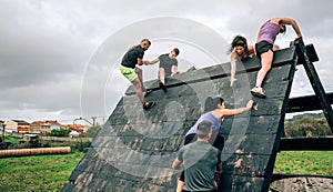 Participants in obstacle course climbing pyramid obstacle