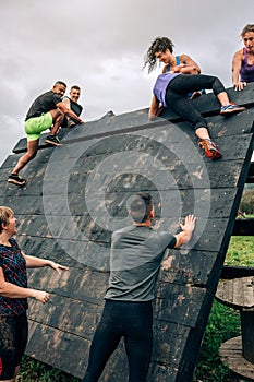 Participants in obstacle course climbing pyramid obstacle