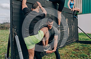 Participants in obstacle course climbing wall