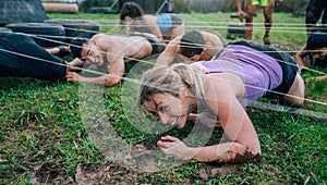 Participants in an obstacle course crawling