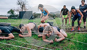 Participants in an obstacle course crawling