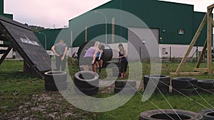 Participants in an obstacle course dragging wheels